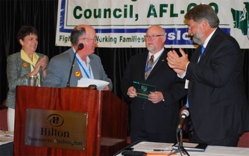 IAM 751 President Tom Wroblewski receives the 2013 Mother Jones Award from WSLC Vice President Bob Guenther on Thursday.