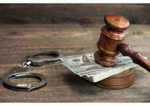 Dollar Banknotes, Handcuffs And Judge Gavel On Wood Table