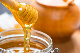 Honey in glass jar and honeycombs wax